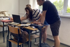 Grupa studentów pochyla się nad monitorem, opracowują zebrane w terenie dane fot. Izabela Borek