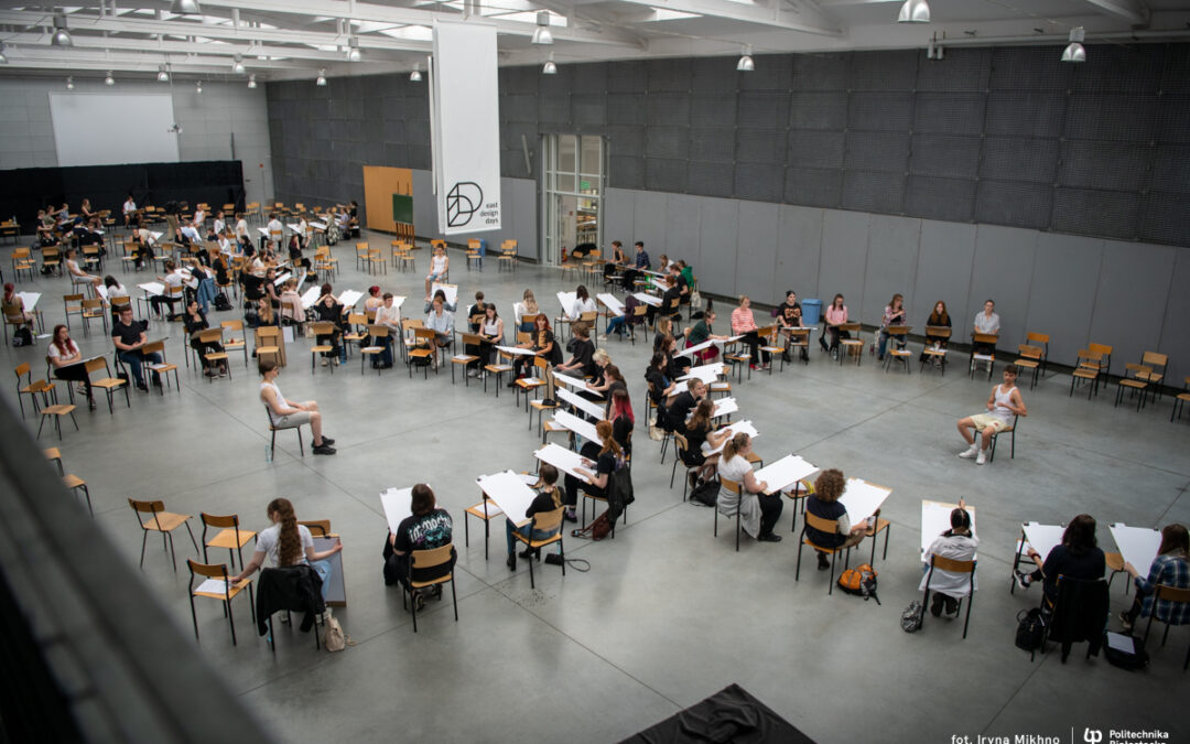na hali Wydziału Architektury grupa młodych ludzi podczas egzaminu wstępnego z rysunku