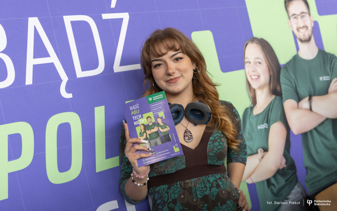 uczennica pozuje na tle ścianki reklamowej Politechniki Białostockiej